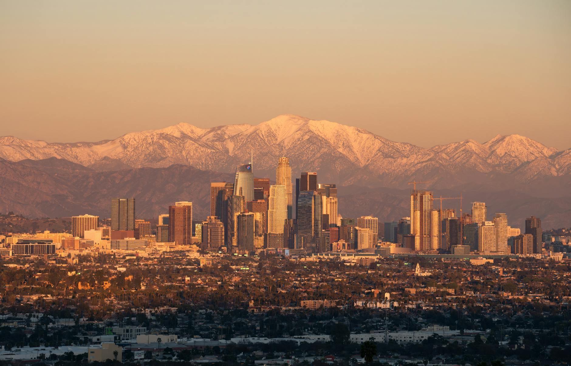 Los Angeles skyline at golden hour with the San Gabriel Mountains in the distance